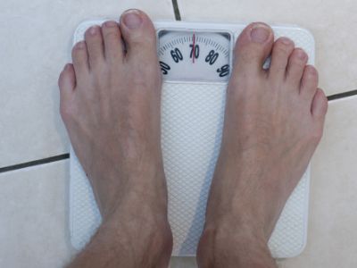 white weighing scale with persons feet